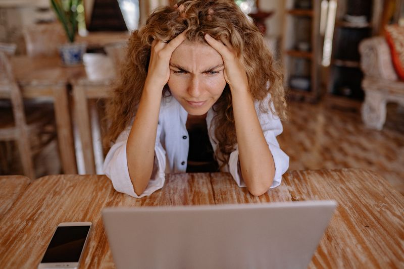 Woman thinking in front of a laptop